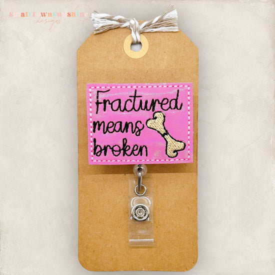 fractured means broken with a cracked bone badge reel
